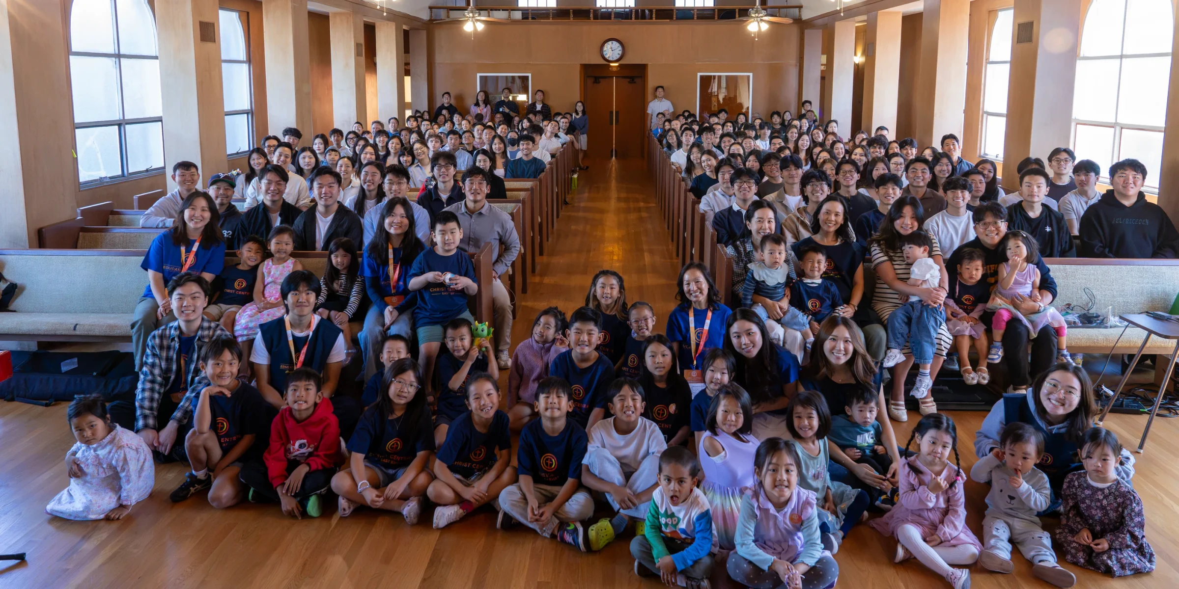 The Christ Central East Bay congregation gathered together in the sanctuary, with children seated in front.